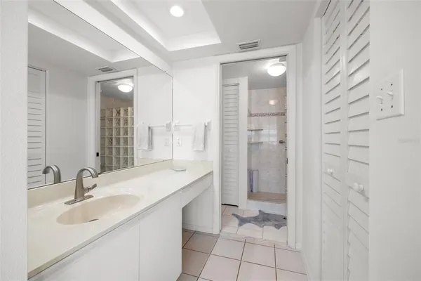 a bathroom with a sink shower and a mirror