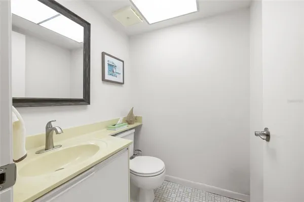 a bathroom with a granite countertop toilet and a sink