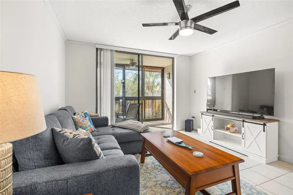a living room with furniture a flat screen tv and a large window