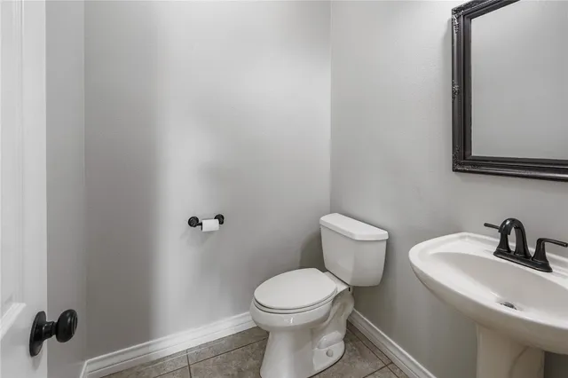 a bathroom with a toilet a sink and mirror