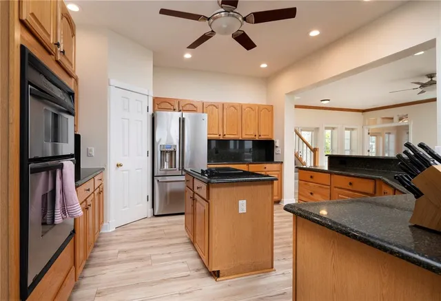 a kitchen with stainless steel appliances granite countertop a refrigerator a stove top oven a sink and dishwasher