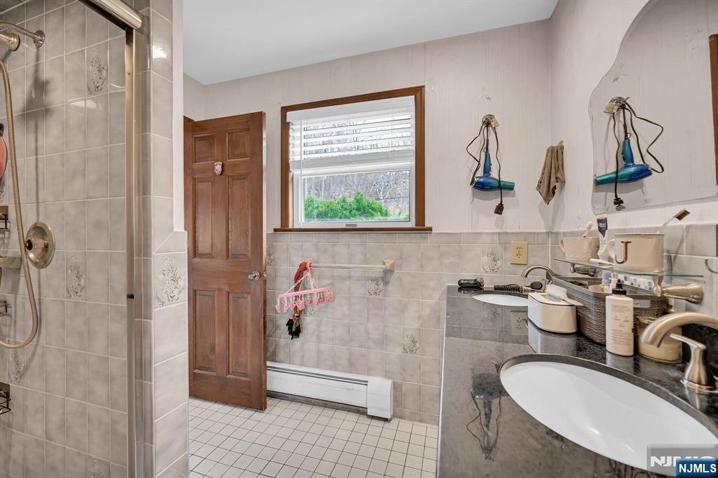 699 Shore Road West Milford, NJ 07421 - Photo 29 of 50 a bathroom with a granite countertop sink a mirror and shower