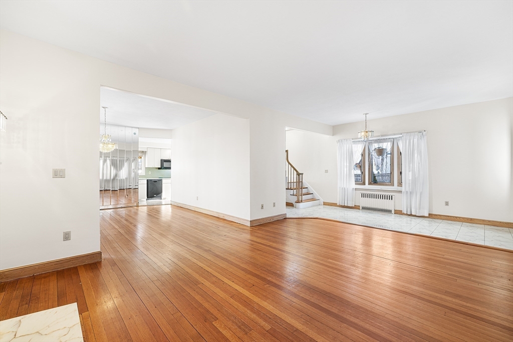 19 Johnson Avenue Winthrop, MA 02152 - Photo 3 of 42 a view of an empty room with wooden floor and kitchen