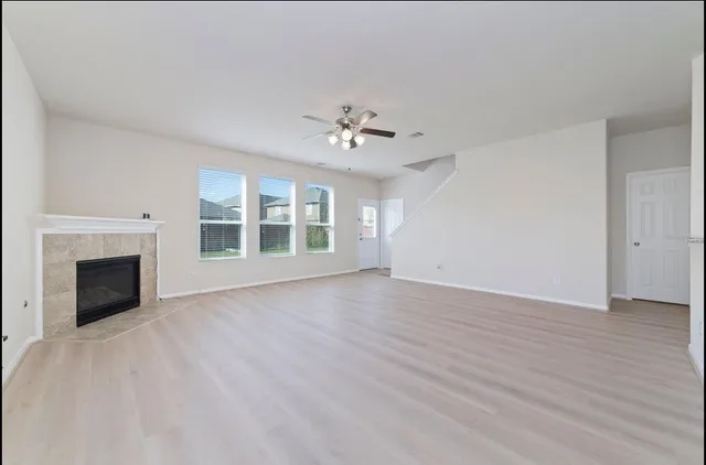 wooden floor fireplace and windows in an empty room