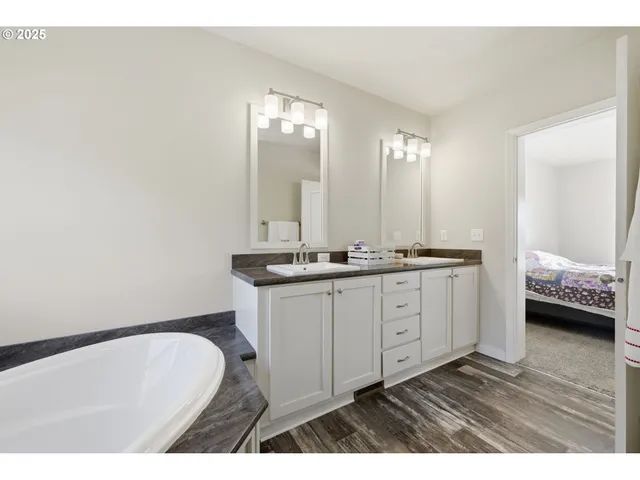 a bathroom with a granite countertop sink a toilet and a window