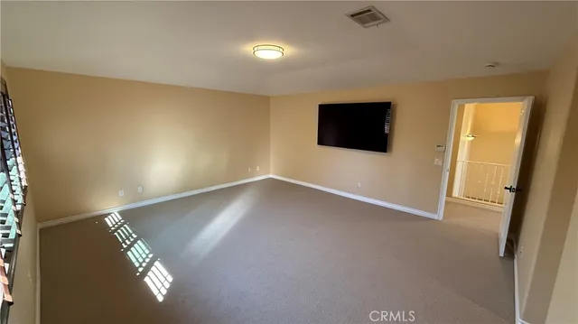 a view of a livingroom with wooden floor and a flat screen tv