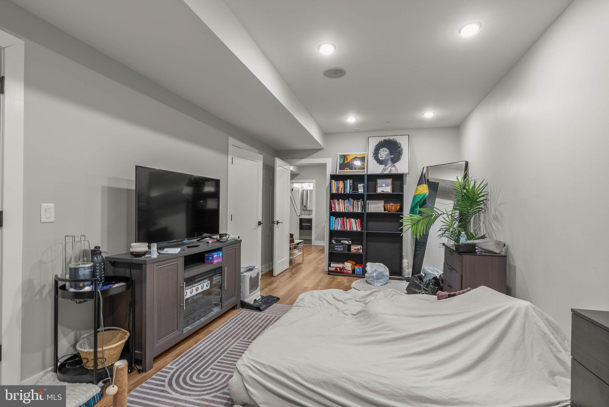 1517 North 27th Street Philadelphia, PA 19121 - Photo 17 of 31 a bedroom with a bed a flat screen tv and a book shelf
