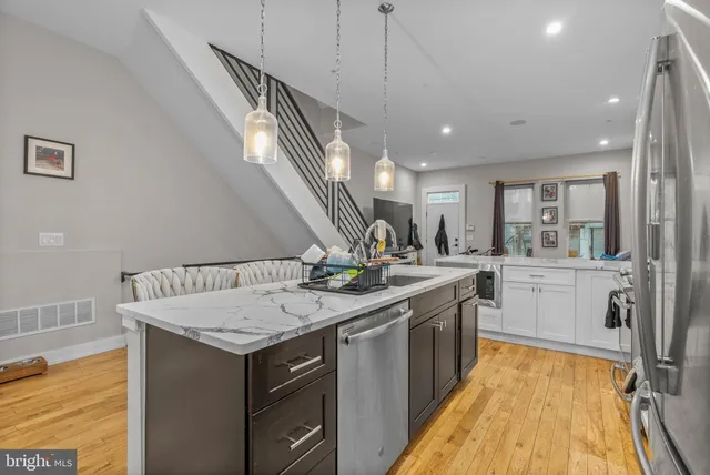 a kitchen with kitchen island a large counter top space a sink stainless steel appliances and cabinets