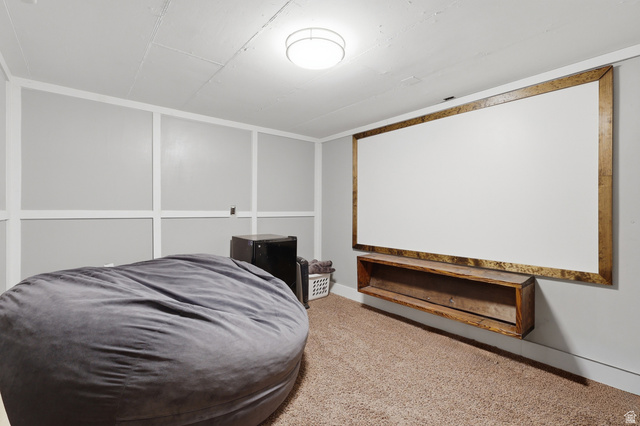 85 North 800 West Provo, UT 84601 - Photo 22 of 25 Entertainment space featuring a large wall-mounted screen with a wood-finish frame, a floating wood-finish shelf, and wall paneling