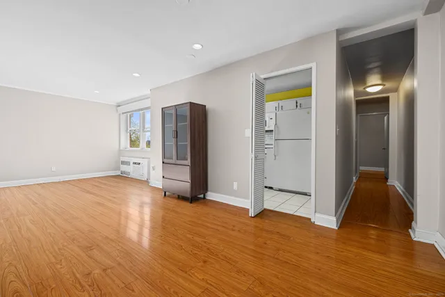 a view of empty room with wooden floor