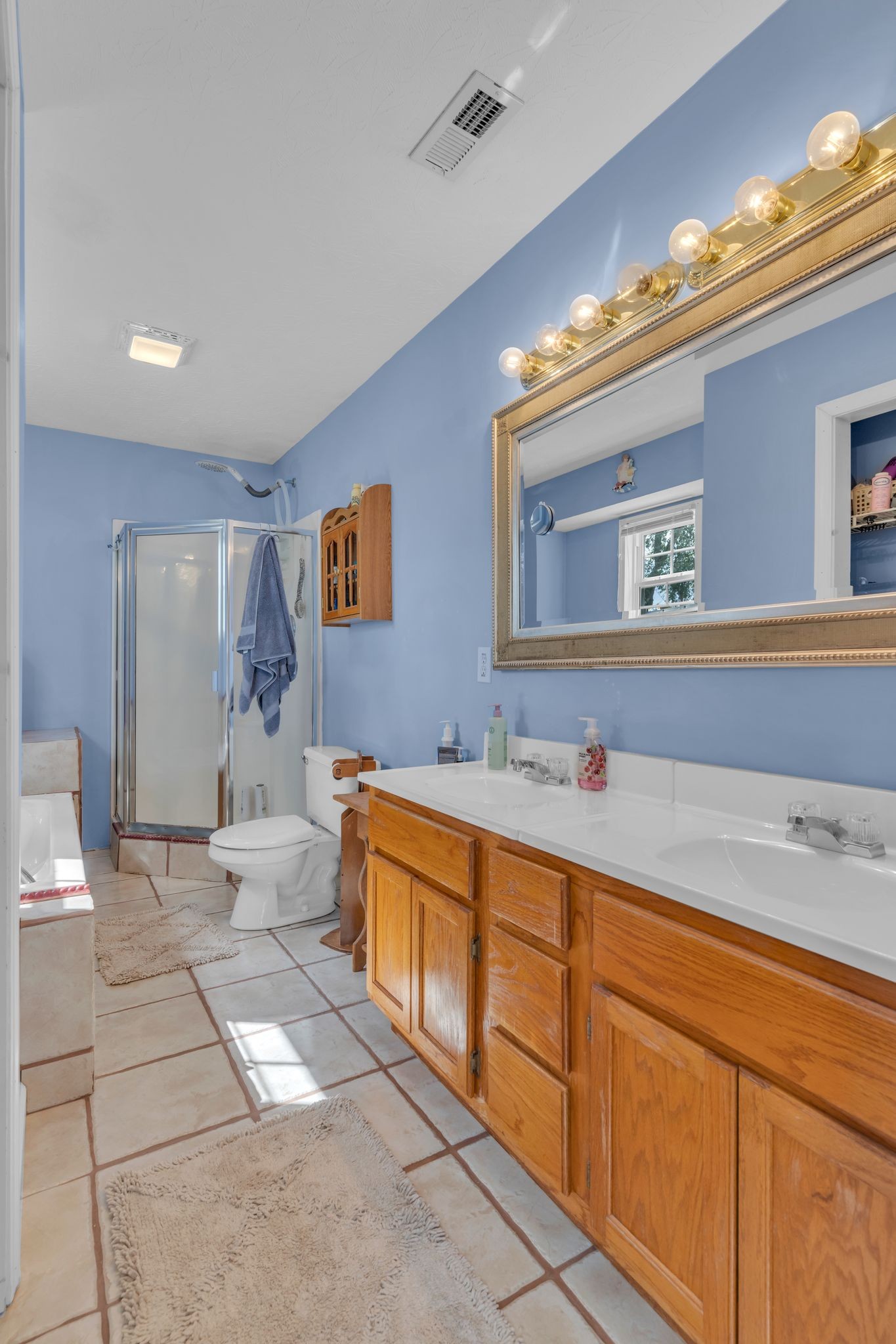 1584 Errel Dowlen Road Pleasant View, TN 37146 - Photo 22 of 28 a spacious bathroom with a double vanity sink a mirror and a bathtub