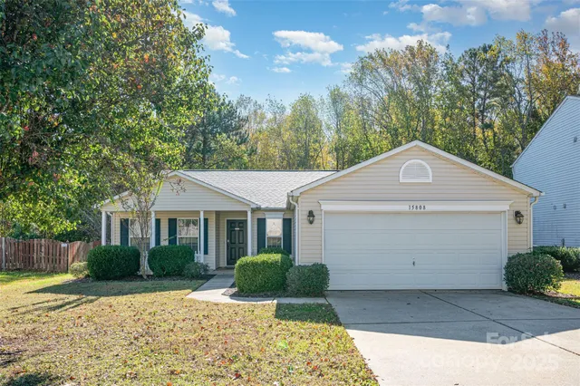 a front view of a house with a yard and trees