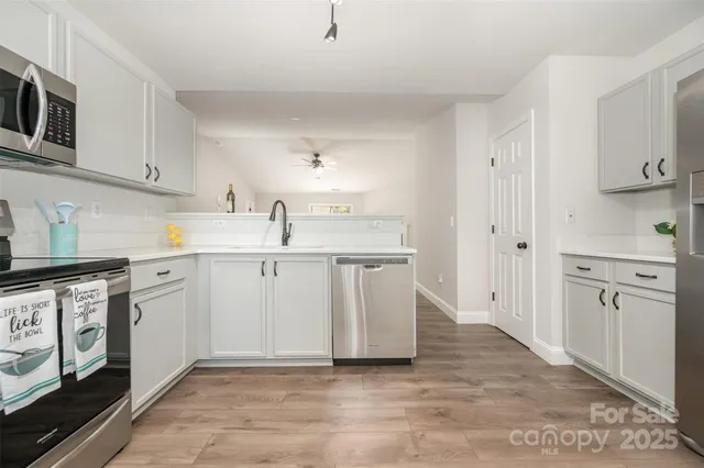 a kitchen with white cabinets and sink