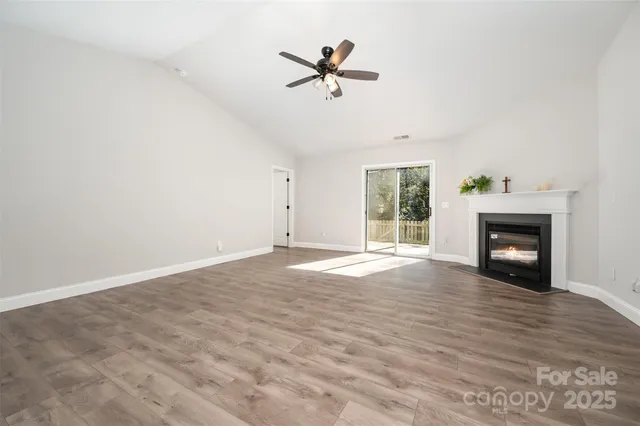 an empty room with fan and windows