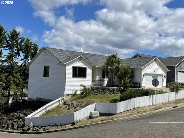 a front view of a house with a garden and plants