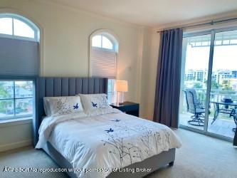 120 Jupiter Key Road, Unit PH 4 Jupiter, FL 33477 - Photo 13 of 20 a bed sitting in a bedroom next to a window