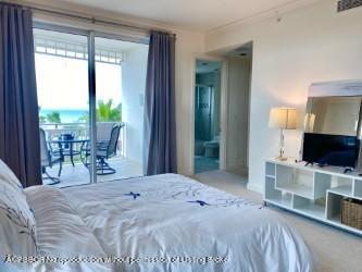 120 Jupiter Key Road, Unit PH 4 Jupiter, FL 33477 - Photo 14 of 20 a bedroom with a bed and large glass window