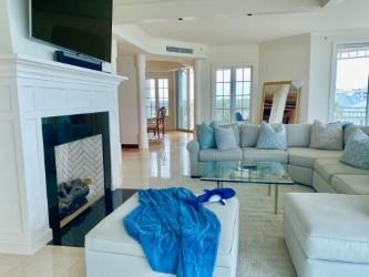 120 Jupiter Key Road, Unit PH 4 Jupiter, FL 33477 - Photo 3 of 20 a living room with furniture a flat screen tv and a fireplace