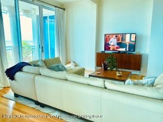 120 Jupiter Key Road, Unit PH 4 Jupiter, FL 33477 - Photo 5 of 20 a living room with furniture and a flat screen tv