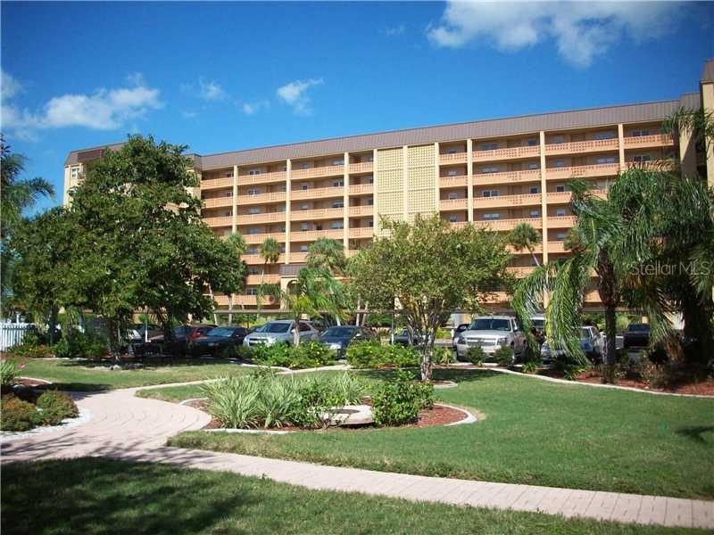 9 Haig Place, Unit 704 Dunedin, FL 34698 - Photo 1 of 1 a front view of a building with garden