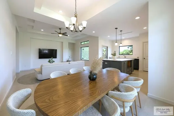 a dining room with wooden floor and chandelier