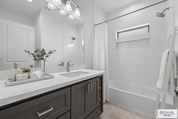 a bathroom with a sink a large mirror and a bathtub