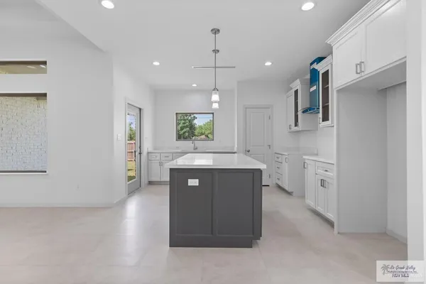 a kitchen with white cabinets and sink