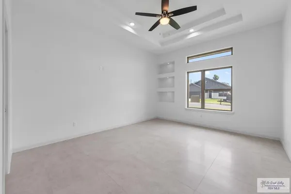 an empty room with a window and ceiling fan