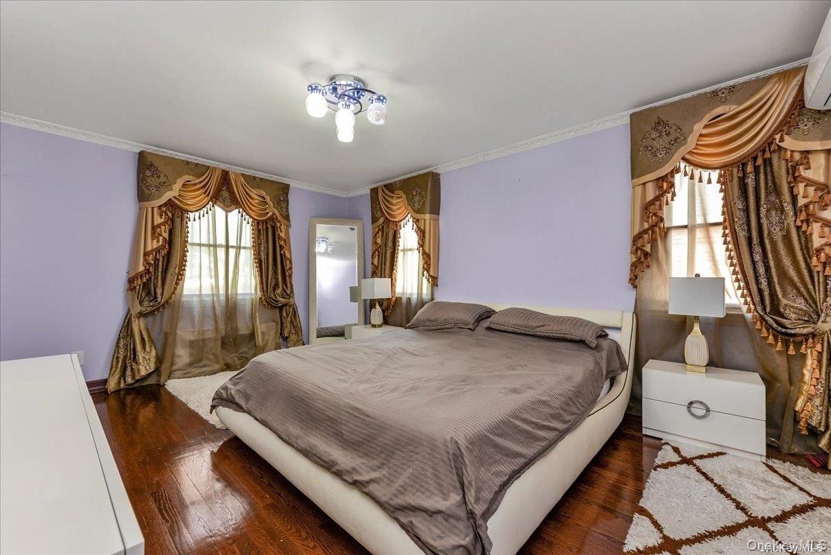 87-67 Chevy Chase Street Queens, NY 11432 - Photo 11 of 22 a bedroom with a bed and a chandelier