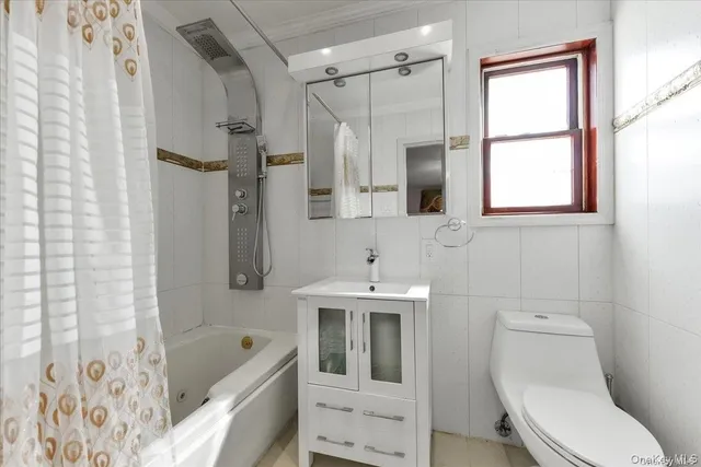 a bathroom with a sink a toilet a window and shower