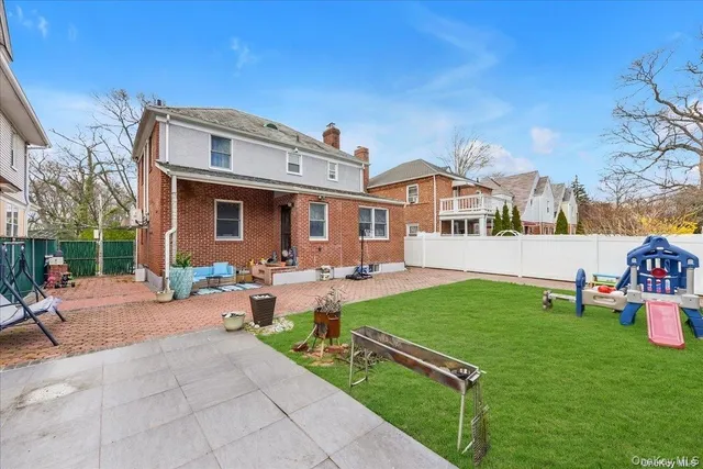 a view of a house with backyard and sitting area