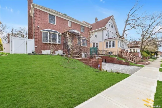 a front view of a house with a yard and trees
