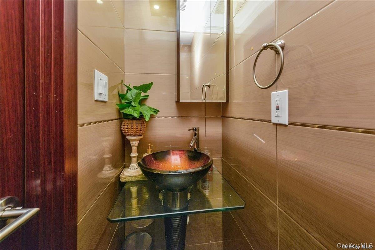 87-67 Chevy Chase Street Queens, NY 11432 - Photo 9 of 22 a bathroom with a sink and a mirror