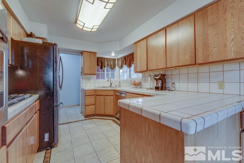 470 Tarn Way Reno, NV 89503 - Photo 7 of 18 a kitchen with kitchen island granite countertop a sink stove and refrigerator