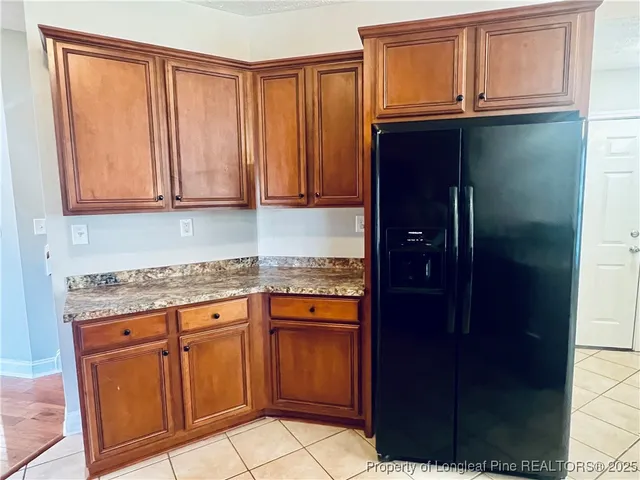 a kitchen with granite countertop cabinets and refrigerator
