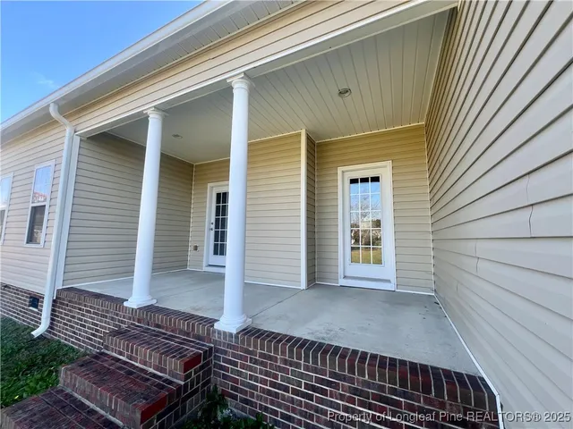 a view of backyard with wooden floor and fence