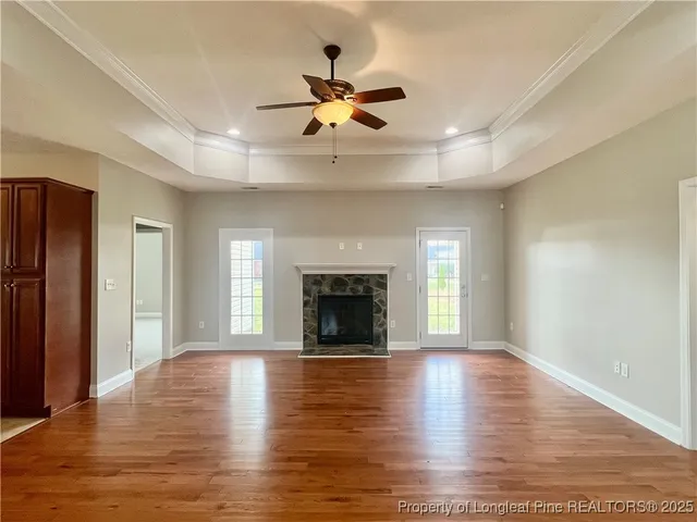 a view of an empty room with window and wooden floor