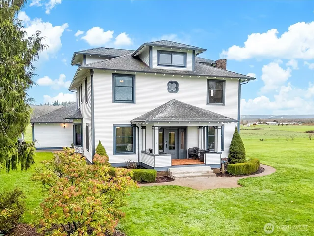 a view of a house with a big yard and large trees