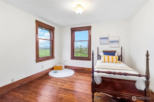 a bedroom with a bed and a table with potted plant