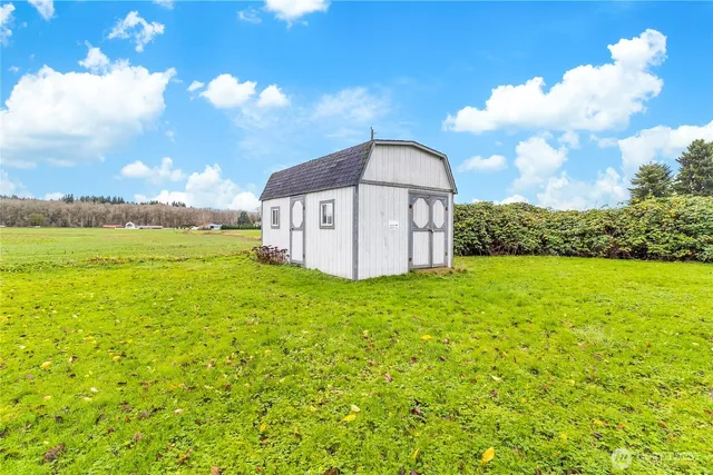 a view of a house with a big yard and large tree