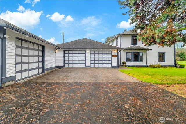 a view of a house with a big yard and large trees