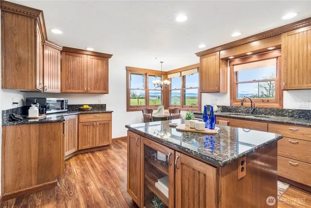 a kitchen with stainless steel appliances granite countertop a sink stove and cabinets