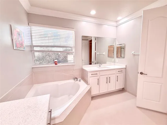 a bathroom with a tub a sink a mirror and a shower