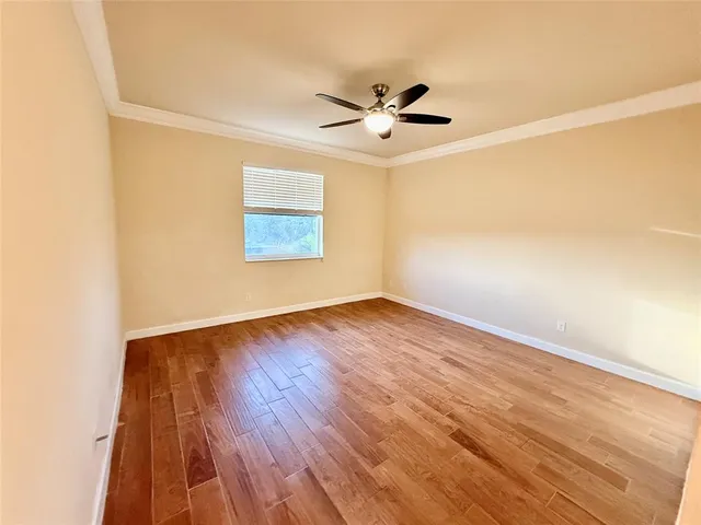 a view of a room with wooden floor and a ceiling fan