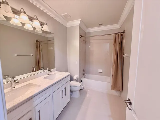 a bathroom with a double vanity sink mirror and toilet