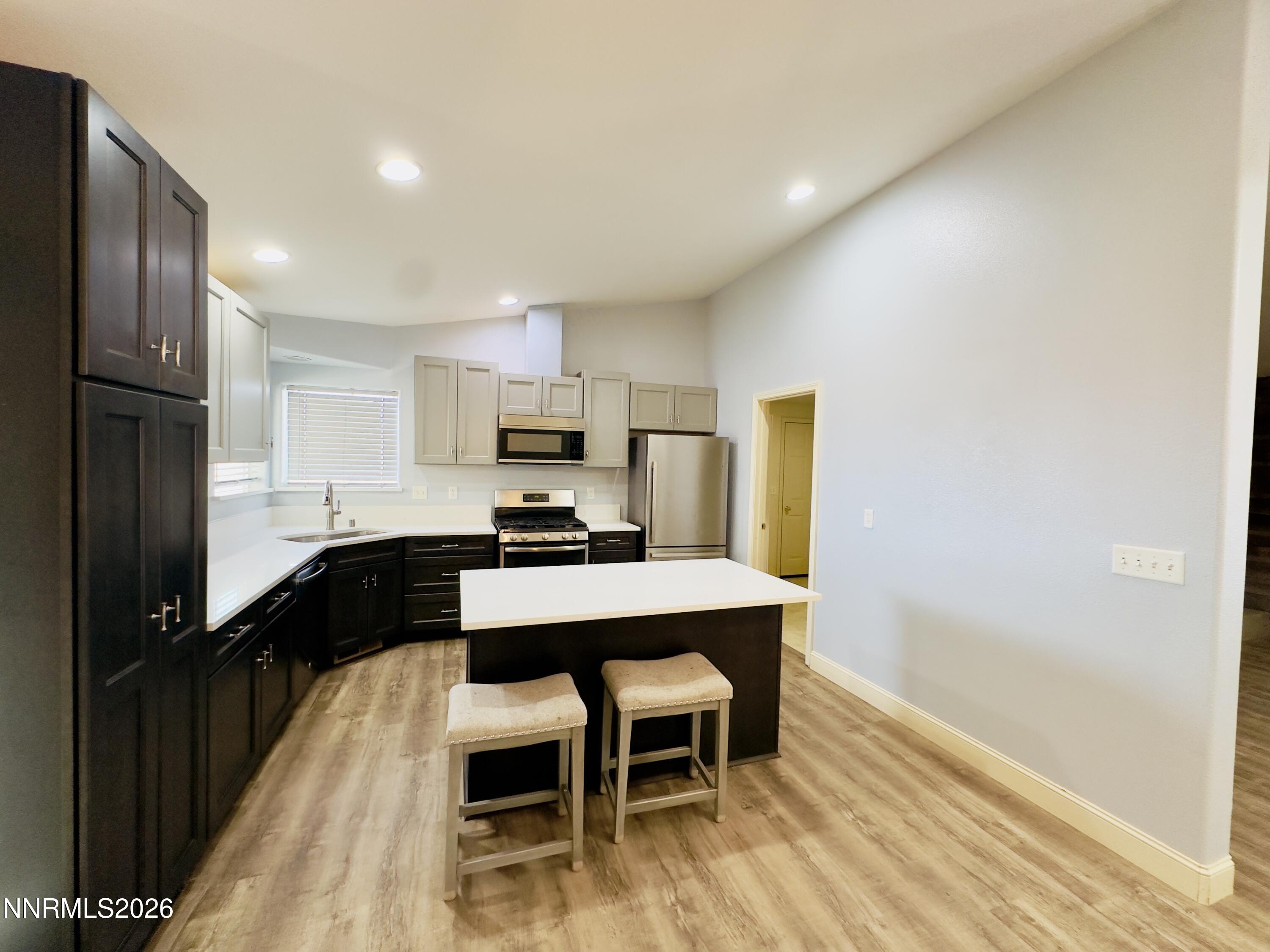 141 Country Ranch Road Fernley, NV 89408 - Photo 41 of 44 a kitchen with stainless steel appliances a dining table chairs stove refrigerator and cabinets