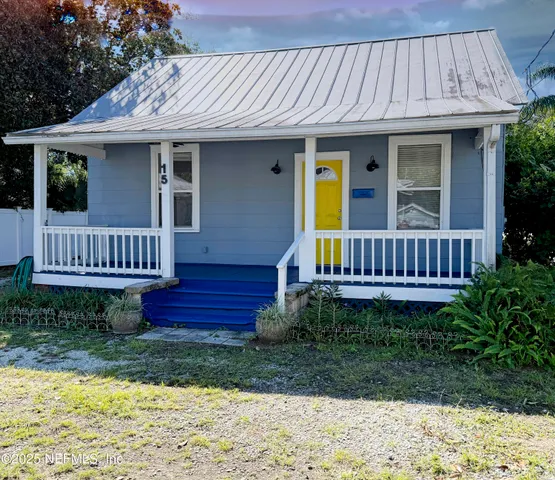 a view of a house with wooden deck and furniture