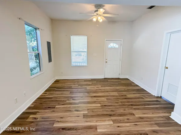a view of empty room with window and ceiling fan