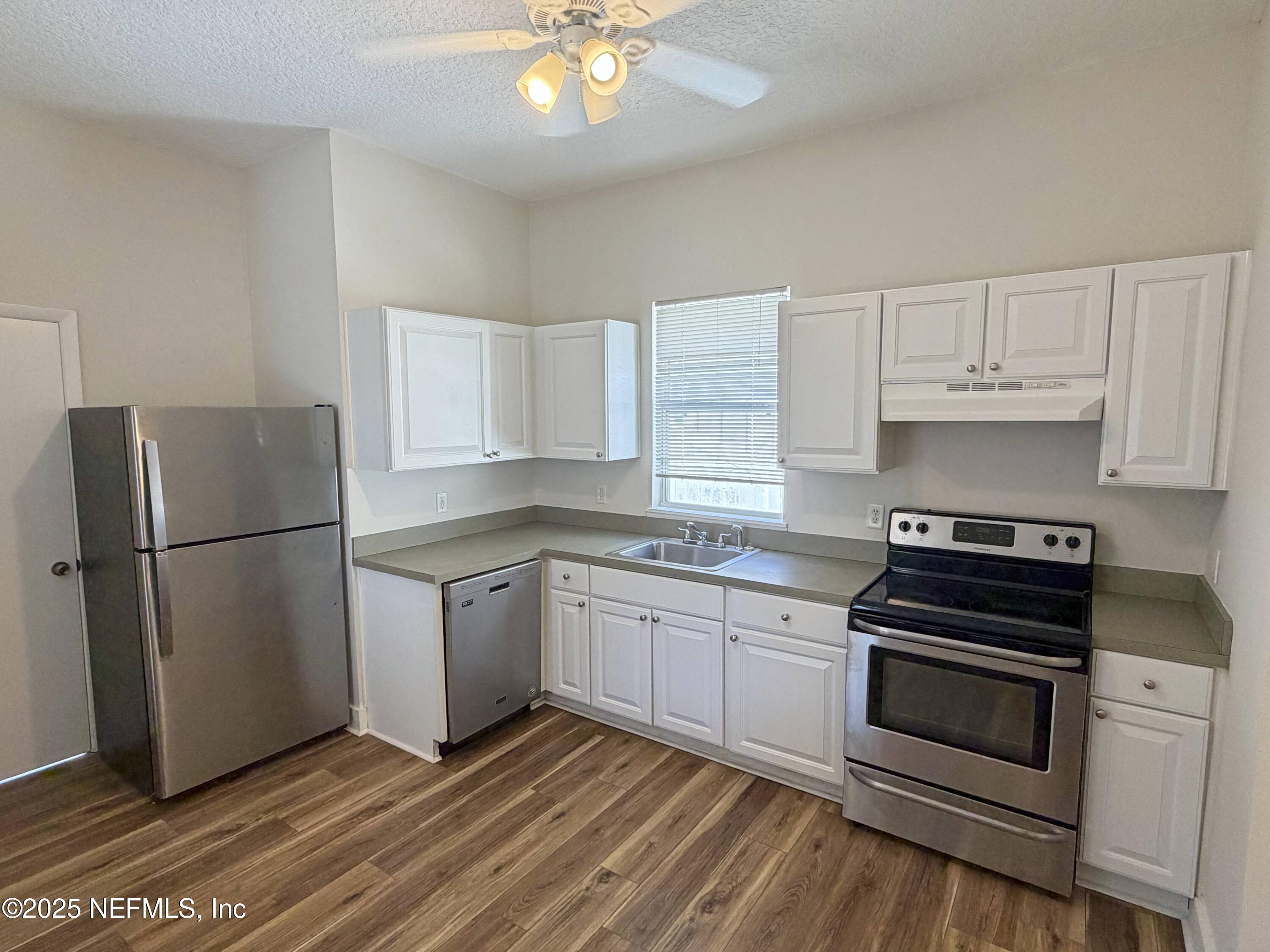 15 Hope Street St. Augustine, FL 32084 - Photo 5 of 16 a kitchen with a refrigerator stove and white cabinets