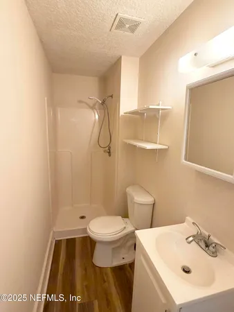 a bathroom with a sink a toilet and shower
